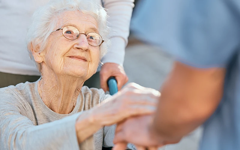 אישה מבוגרת מחזיקה יד של אח בחיוך